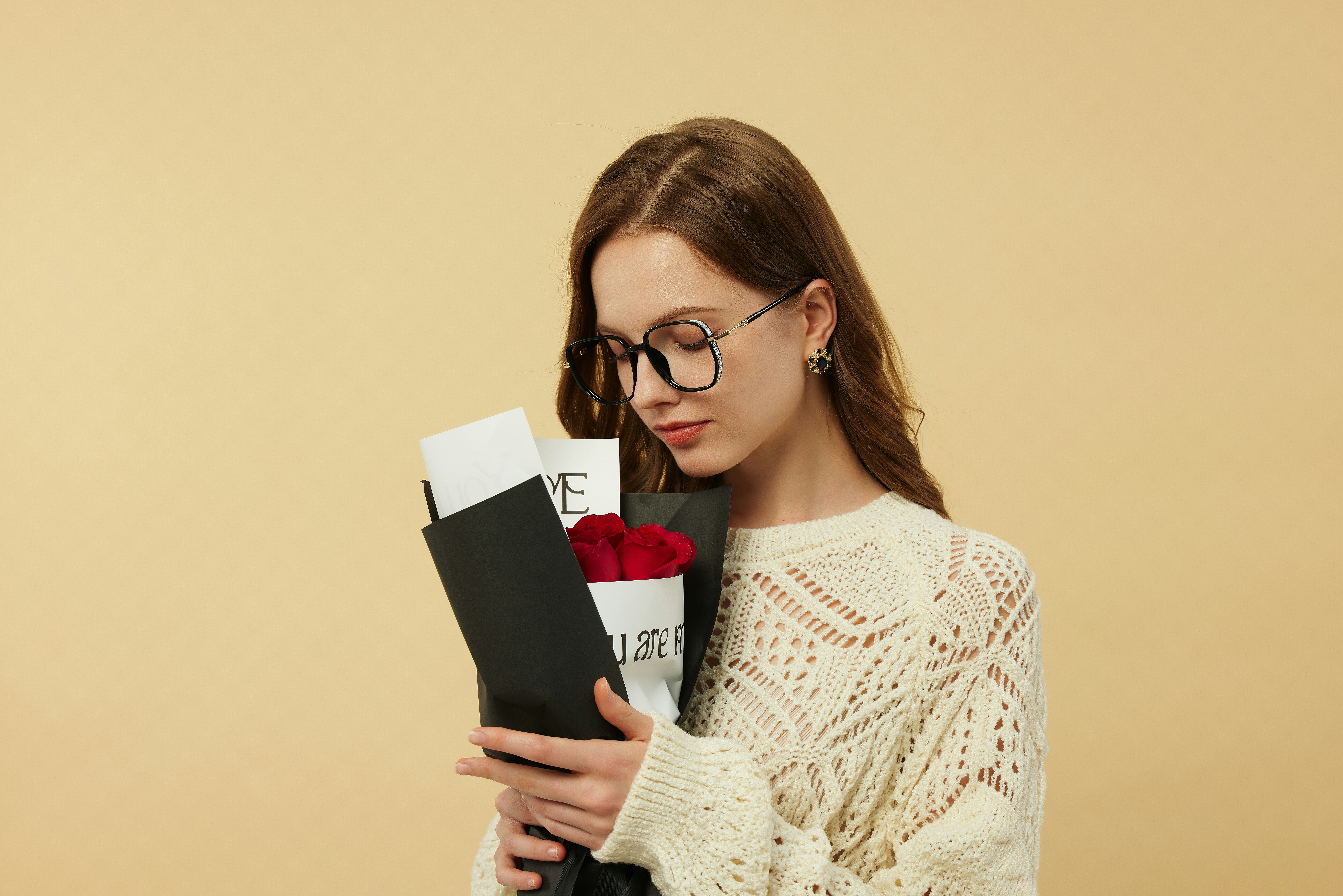 A woman holding a bouquet of flowers and a book