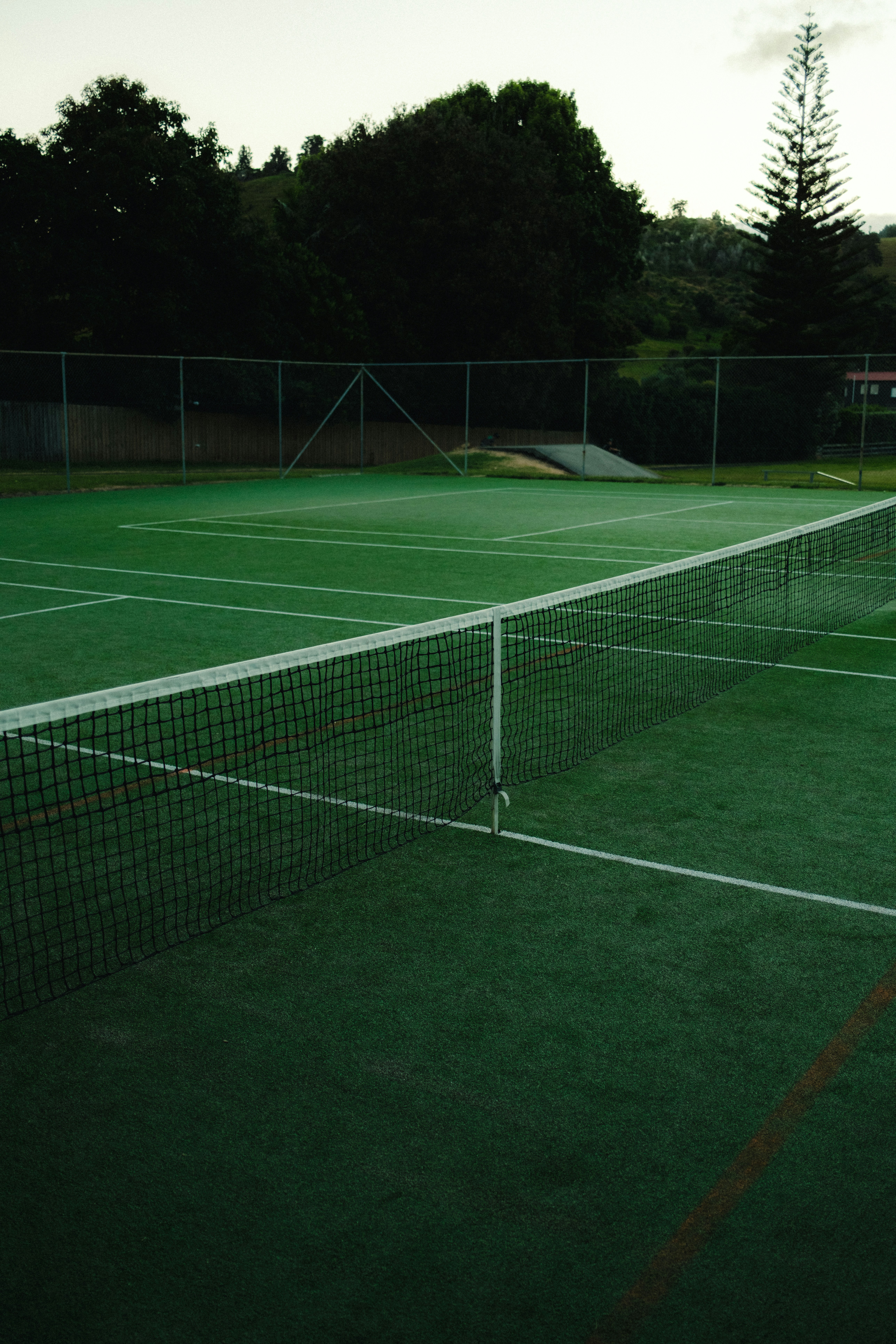 A tennis court with a net on the grass