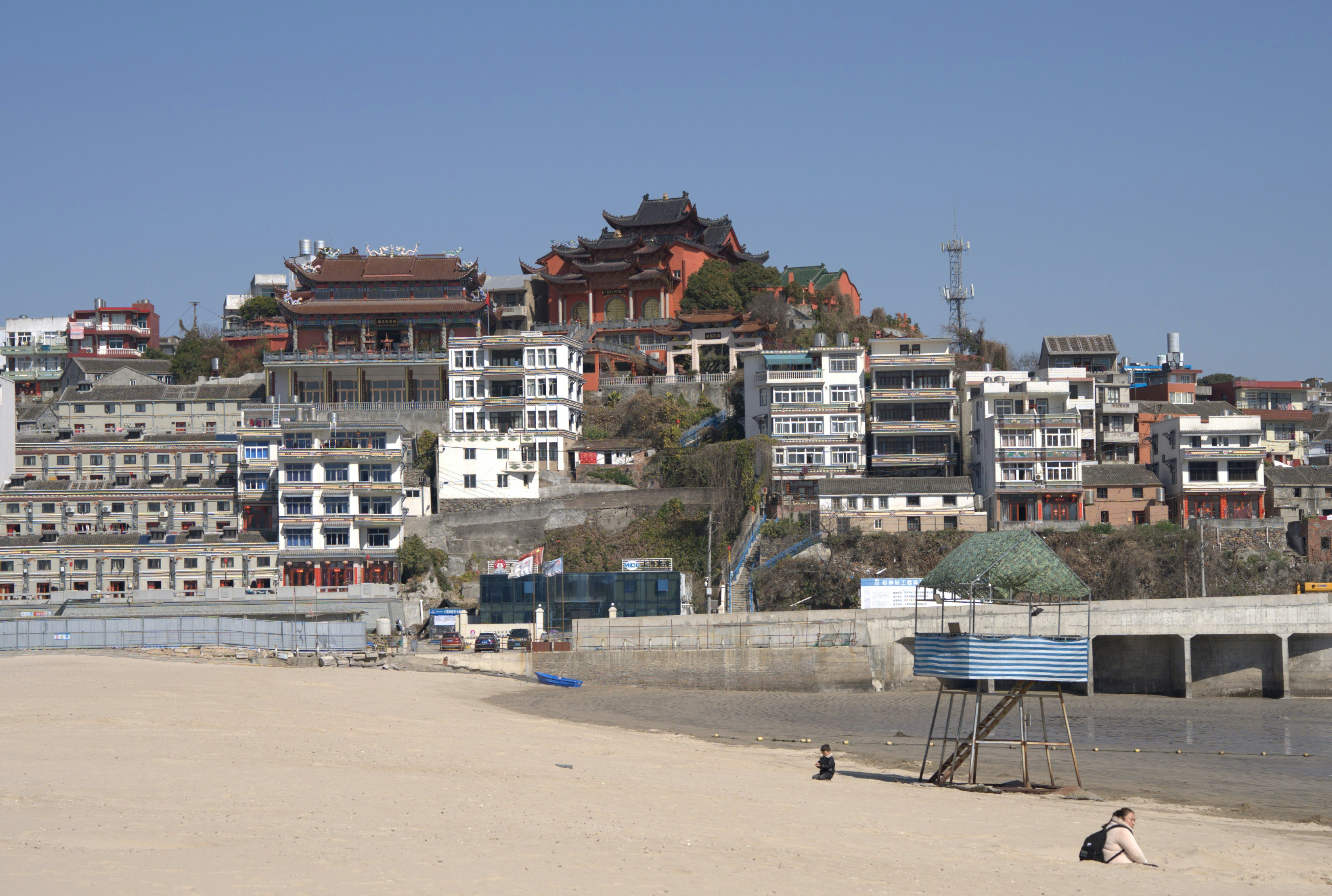 A beach with a bunch of buildings in the background