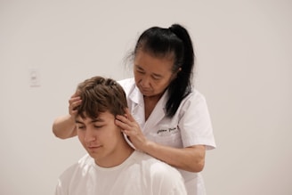 A man getting his hair cut by a woman