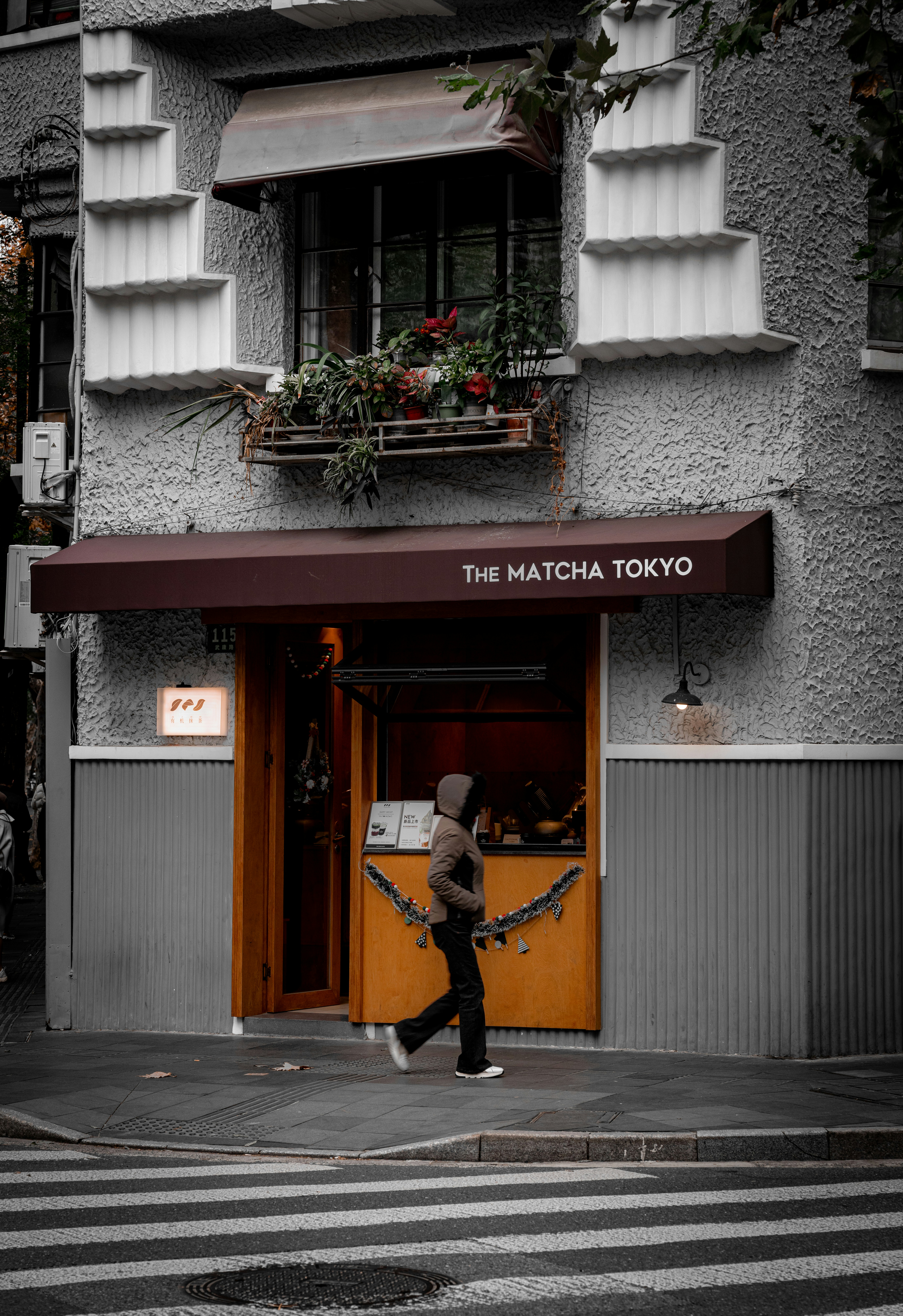 A person crossing the street in front of a building