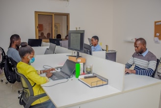 A group of people sitting at desks working on laptops