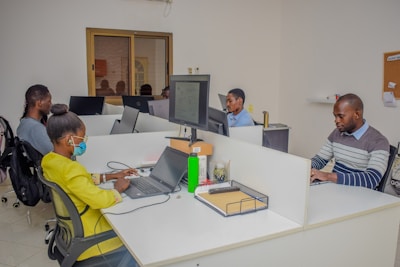 A group of people sitting at desks working on laptops