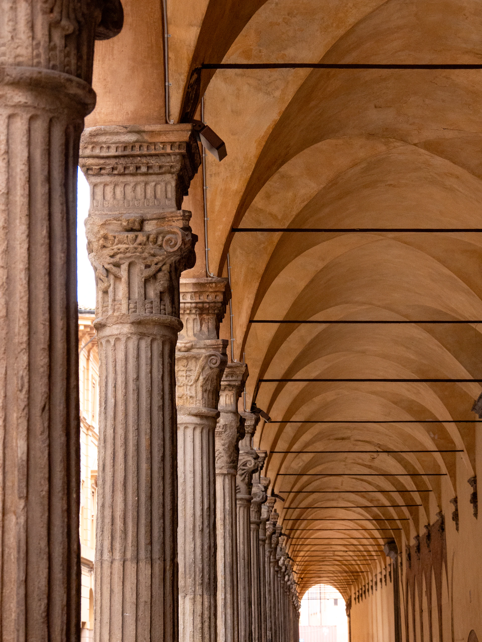 A long hallway with columns and a clock on the wall