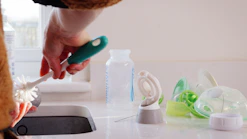 A person using a brush to clean a sink
