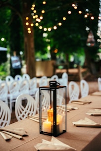 A lantern is lit up on a long table