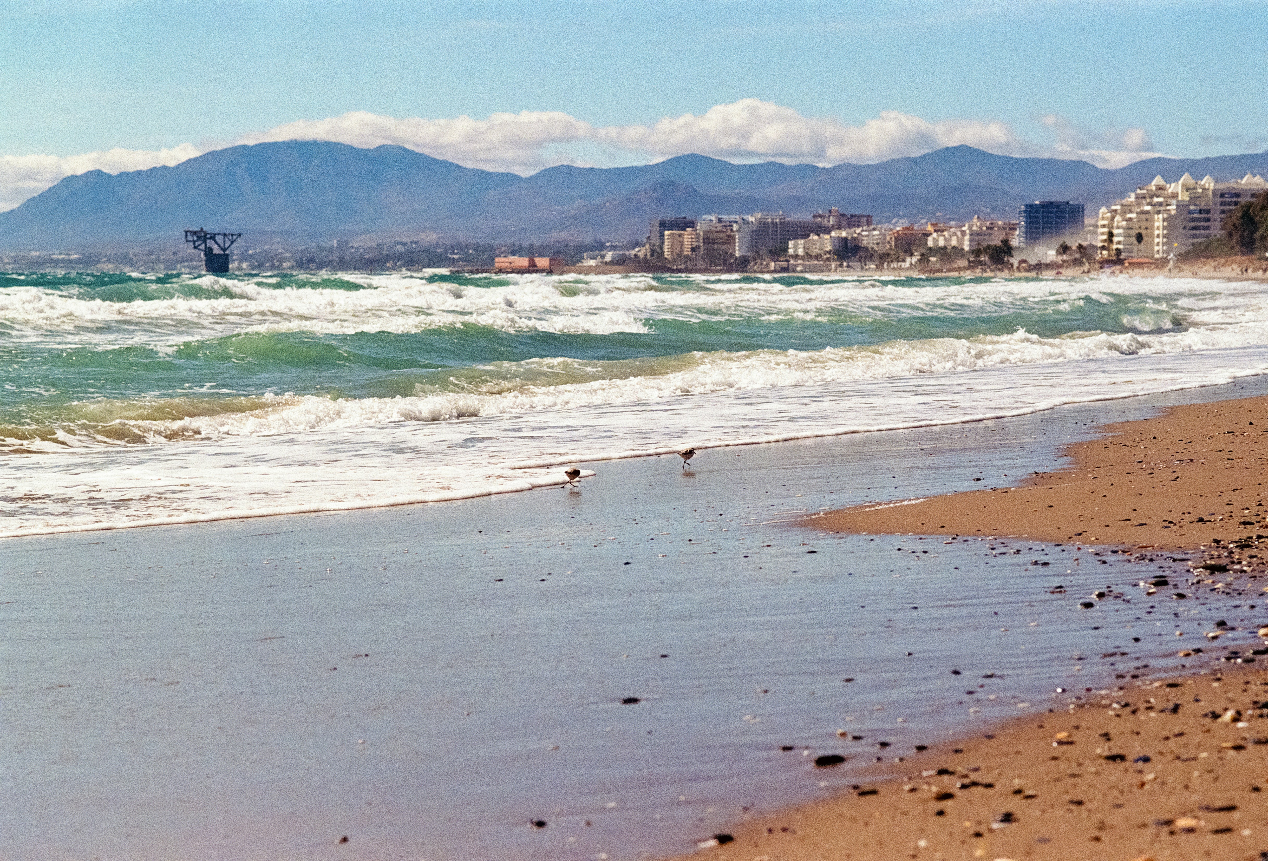 A view of a beach with mountains in the background
