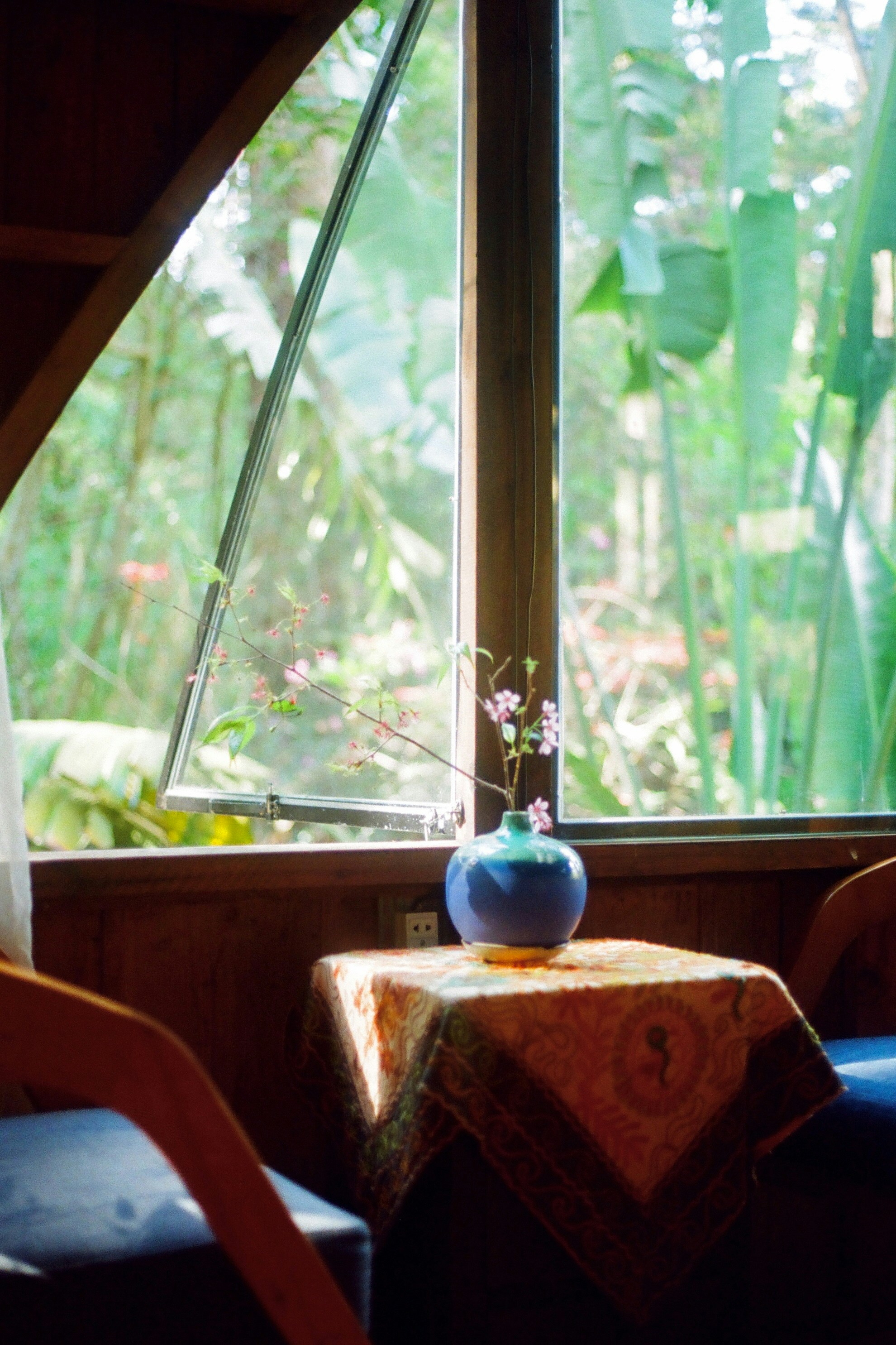 A room with a table, chairs and a vase