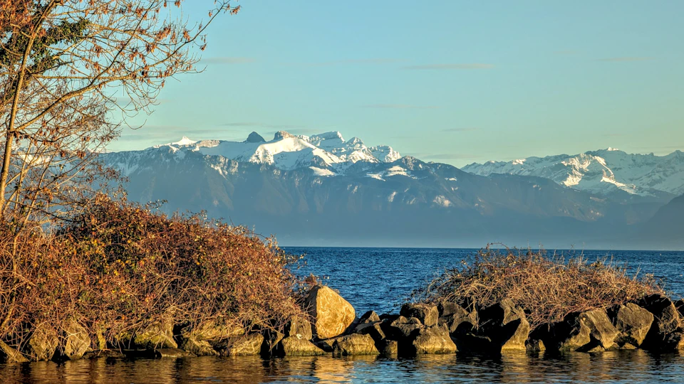 Serene mountain landscape with snow-capped peaks and a deep blue lake below surrounded by rocky