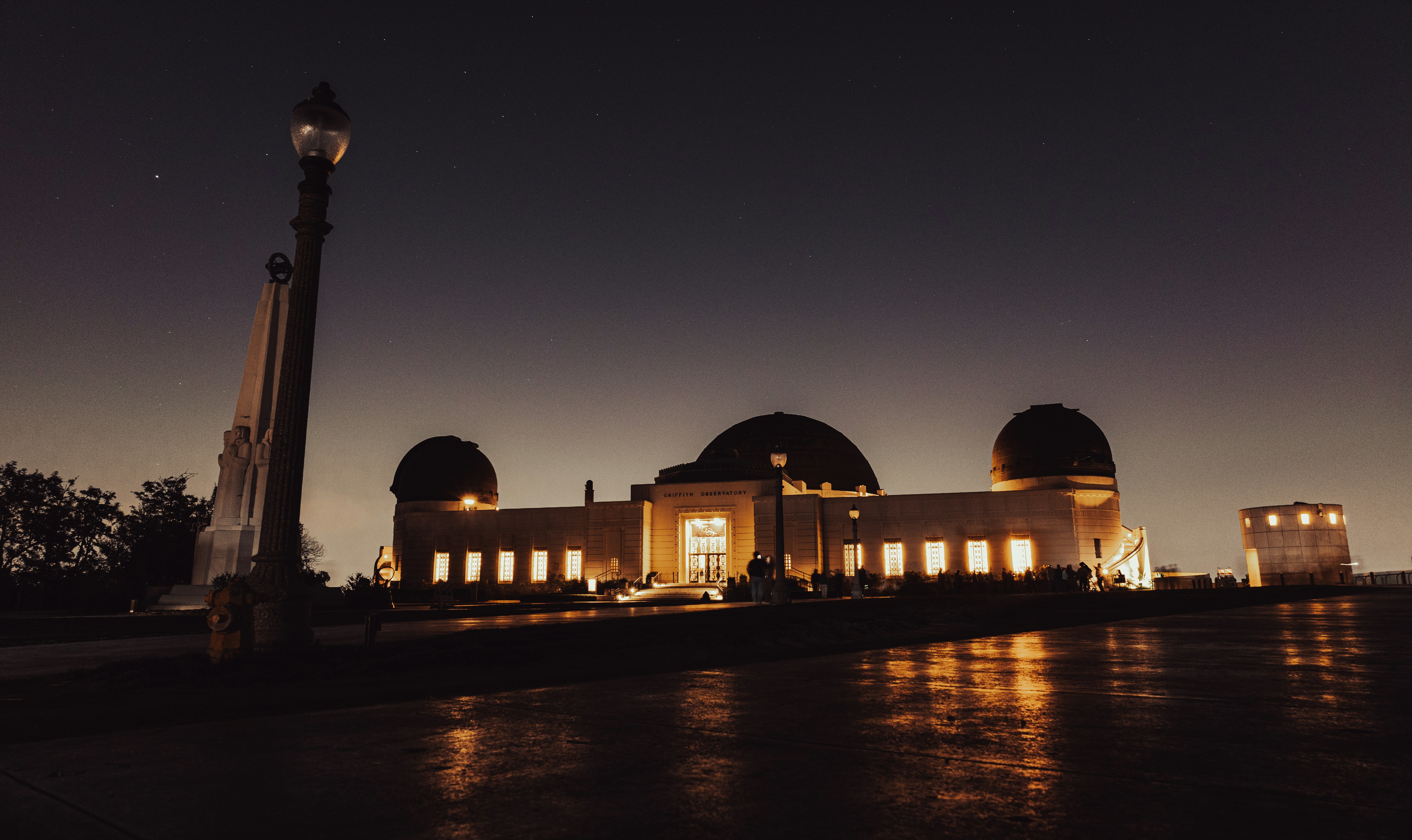 A building lit up at night with a clock tower in the foreground