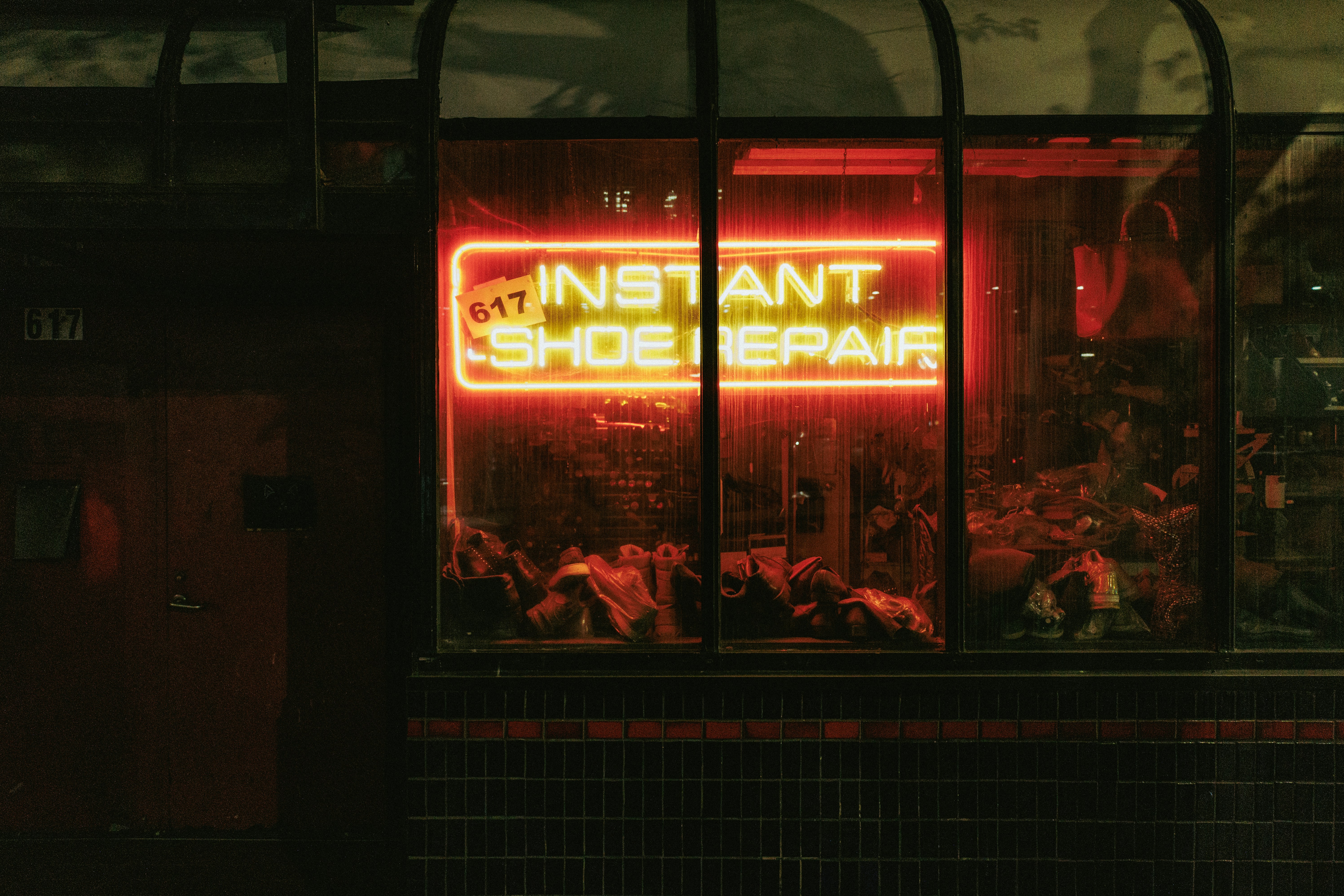A neon sign in the window of a shoe shop