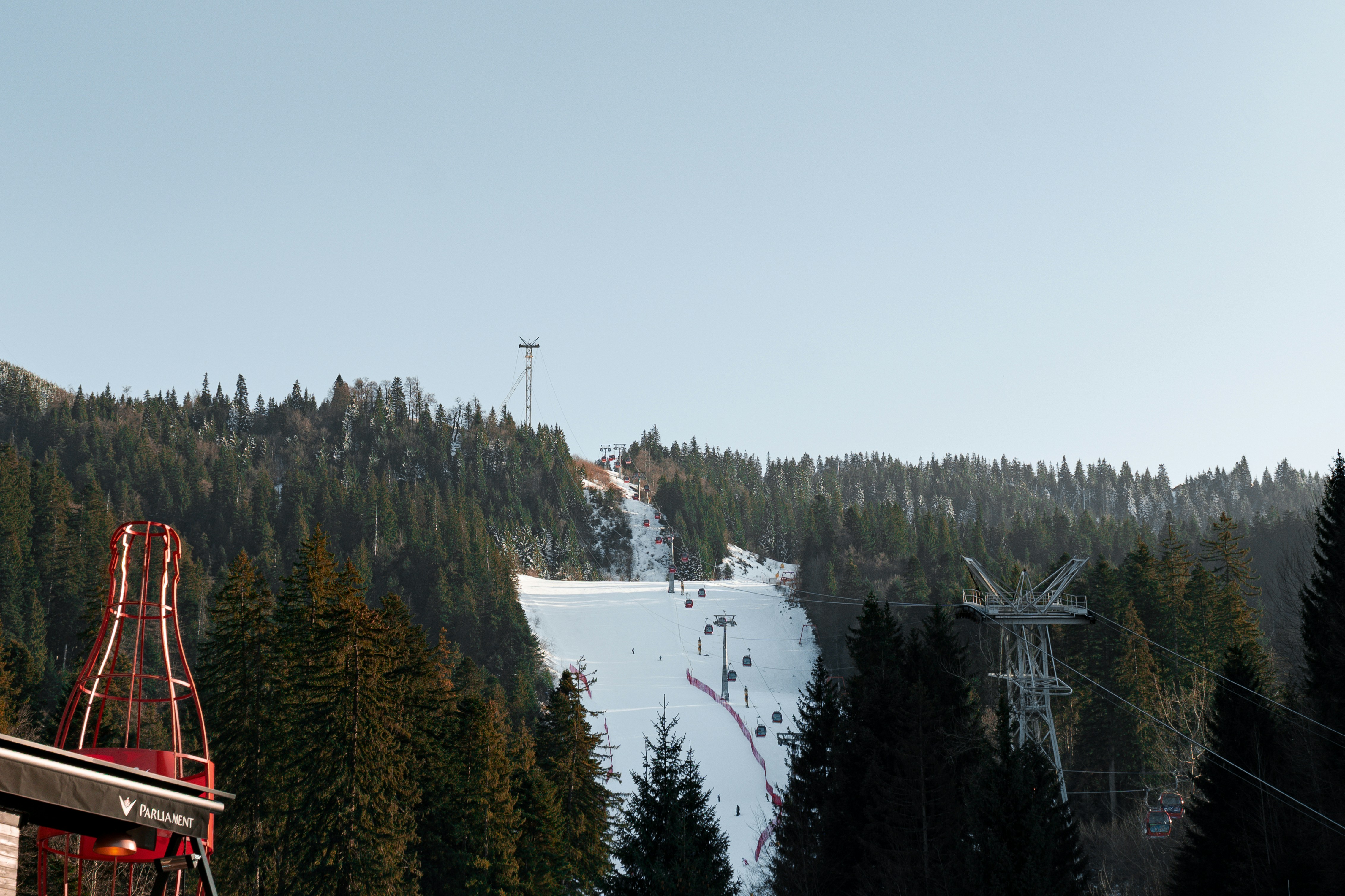 A ski lift going down a snowy mountain, 