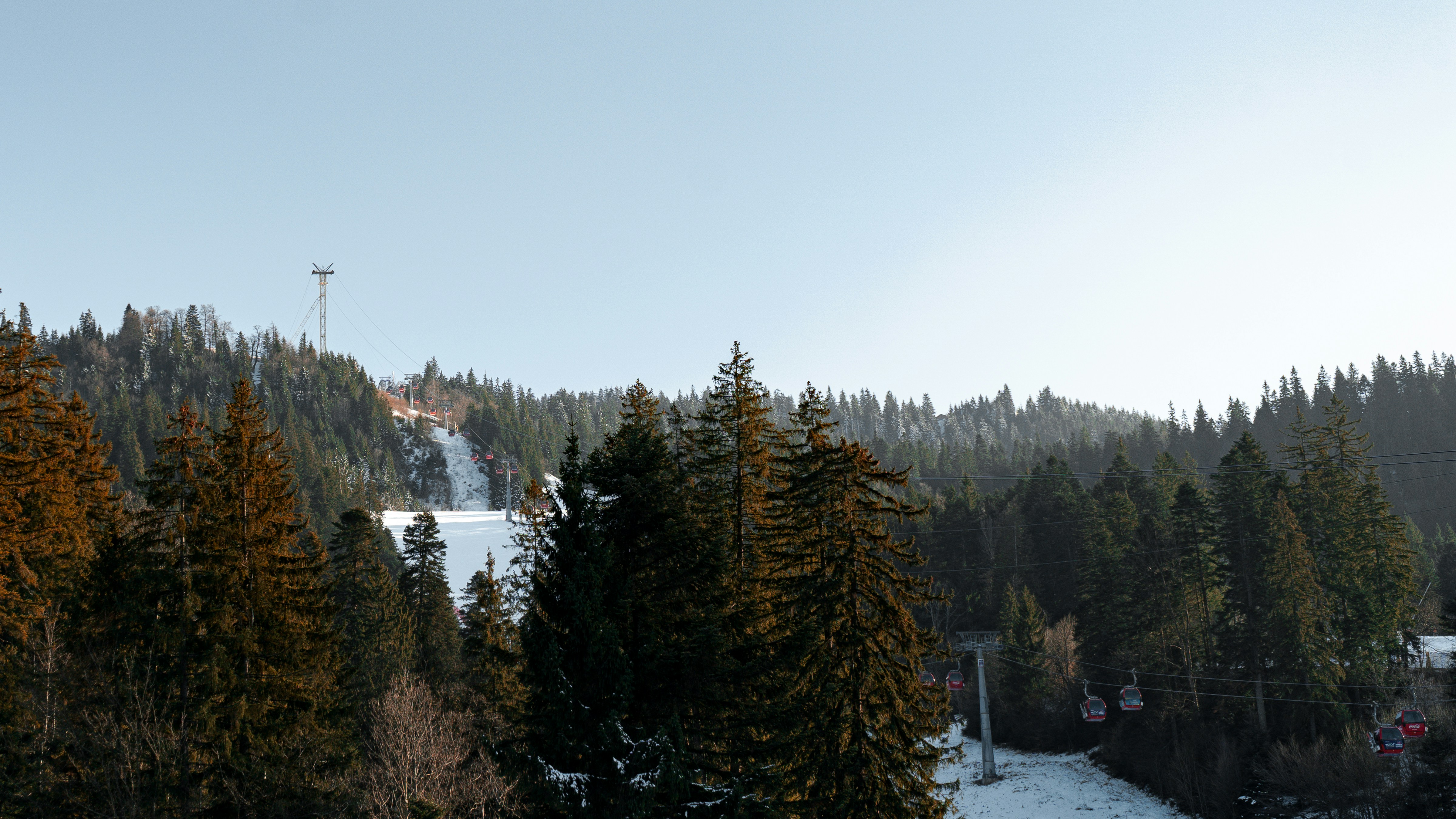 A snowboarder is going down a snowy hill
