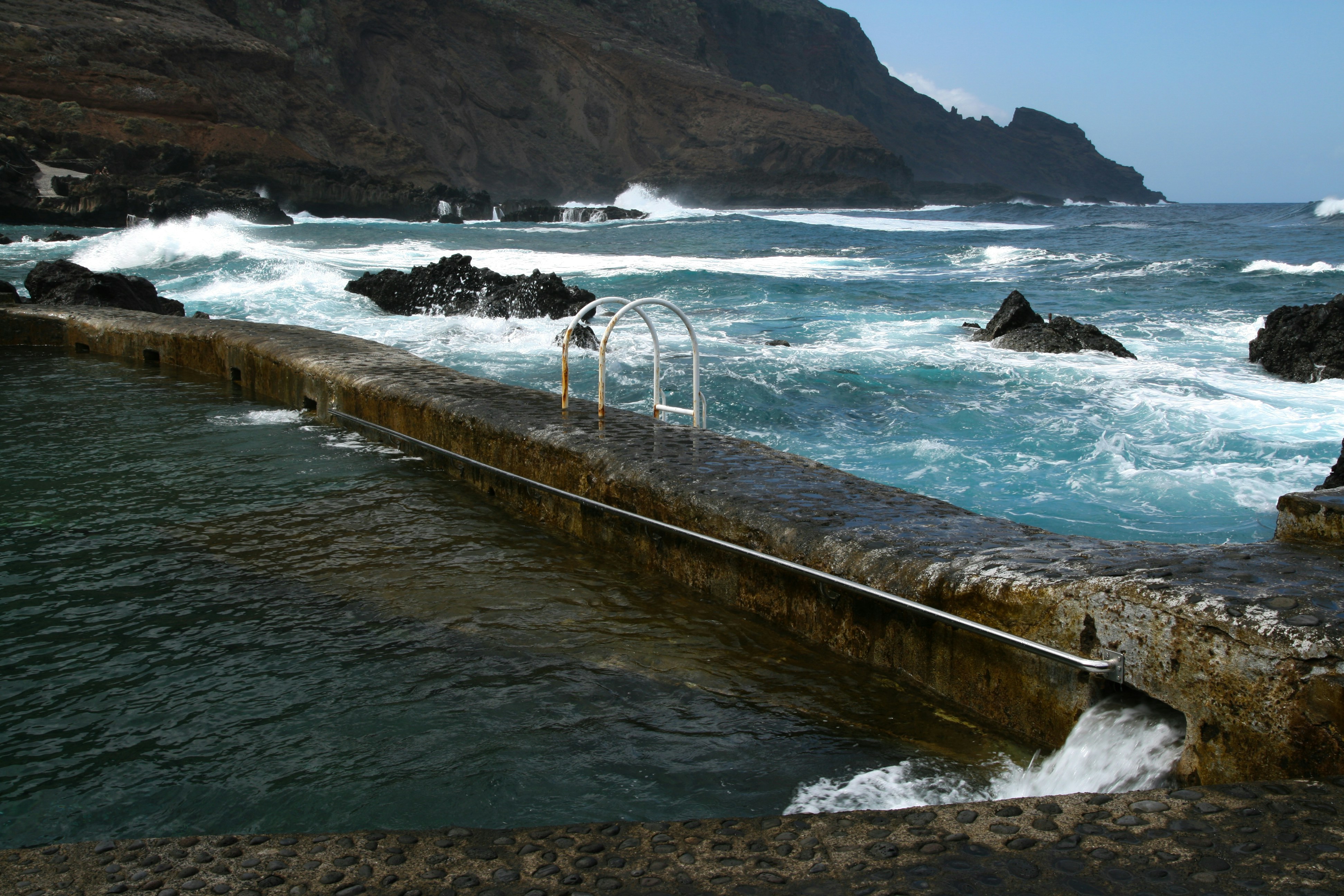 A large body of water next to a rocky shore