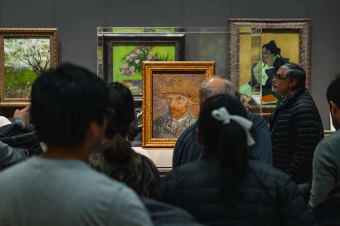 Visitors quietly admiring paintings inside a museum