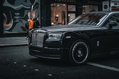A black rolls royce parked on the side of the road