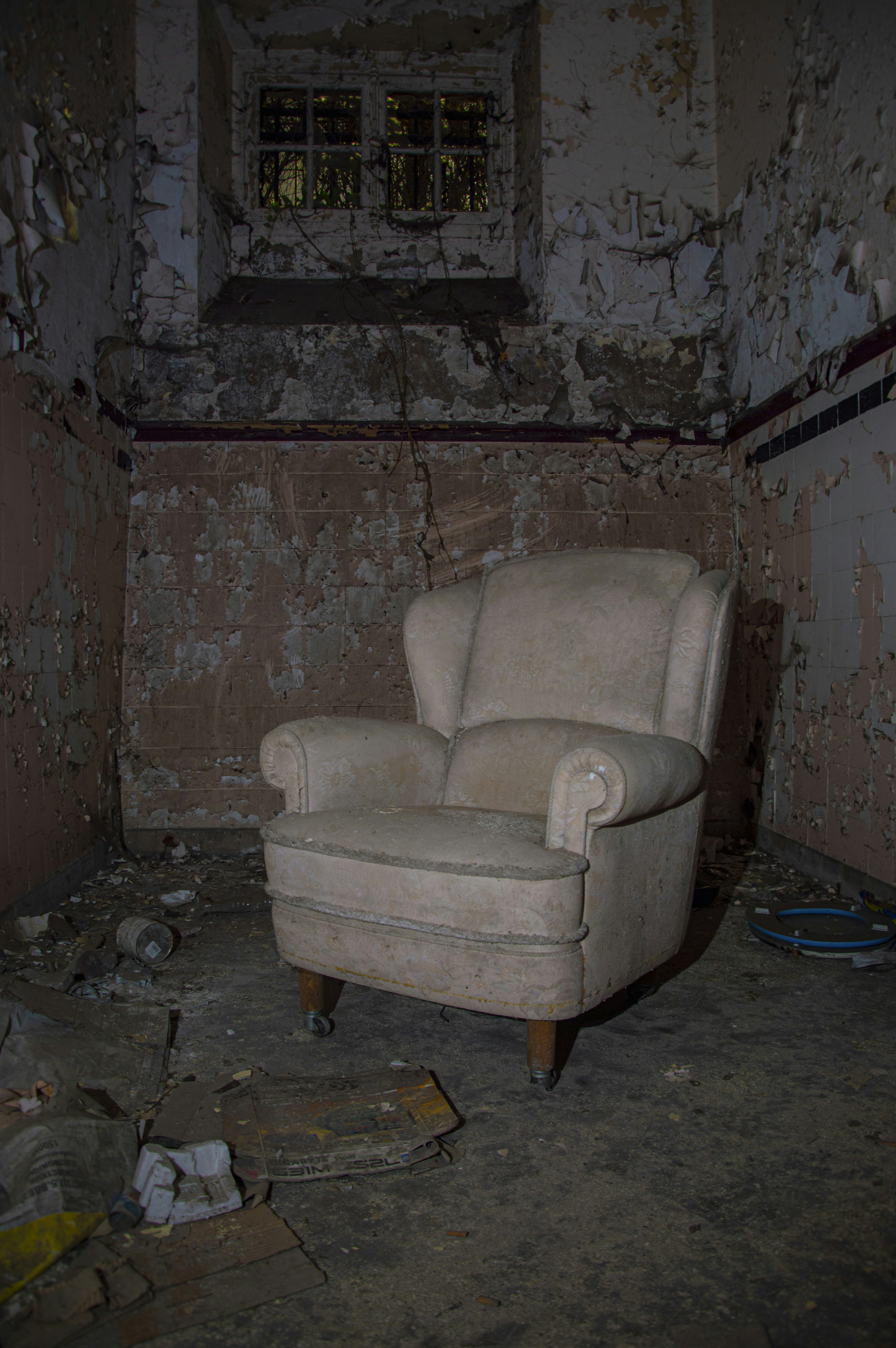 A chair sitting in a room with peeling paint on the walls