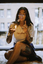 A woman sitting on the floor smoking a cigarette