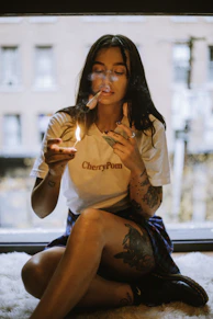 A woman sitting on the floor smoking a cigarette