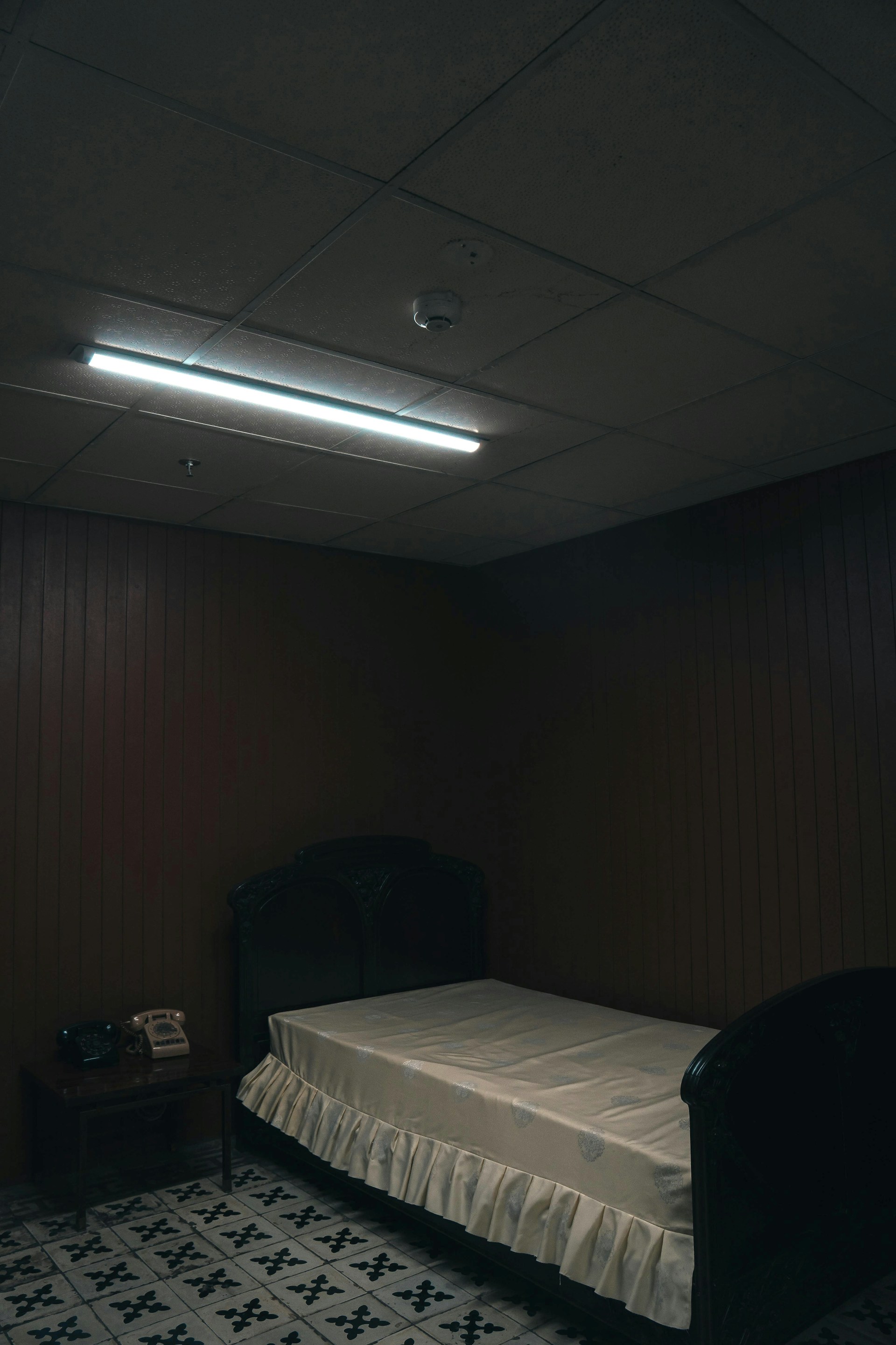 A dimly lit room with a bed and a night stand