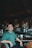 A man sitting at a bar in a green shirt