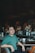 A man sitting at a bar in a green shirt