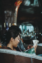 A woman sitting on a bench reading a book