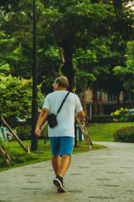 A man walking down a sidewalk carrying a camera