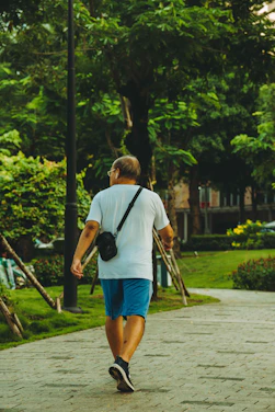 A man walking down a sidewalk carrying a camera