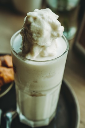 A glass of ice cream sitting on top of a plate