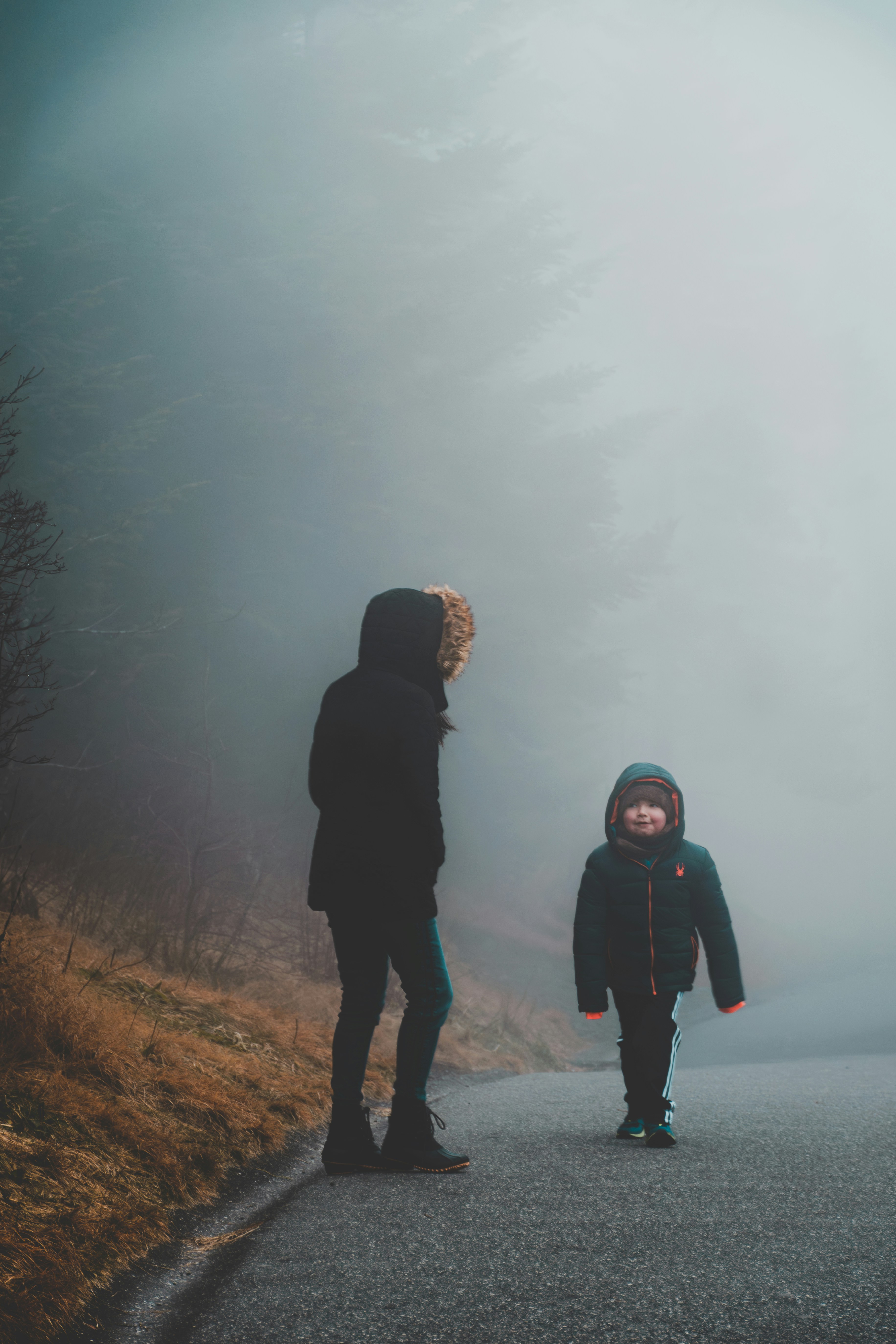 A woman and a child walking down a road