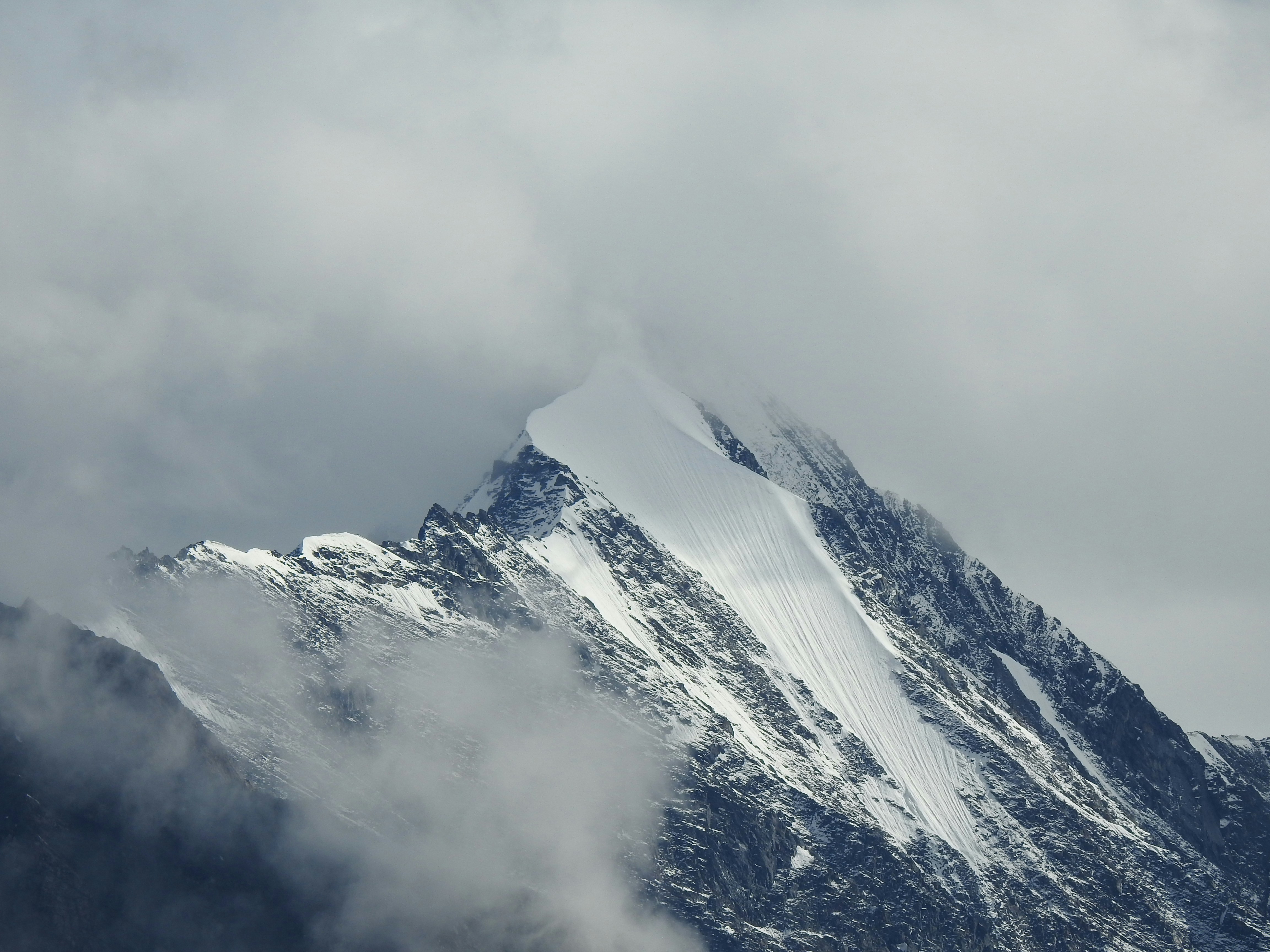 Une montagne enneigée avec des nuages dans le ciel