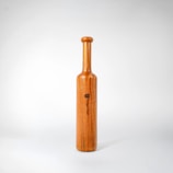 A wooden bottle with a black label on it