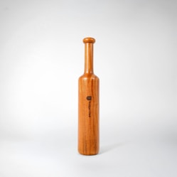 A wooden bottle with a black label on it