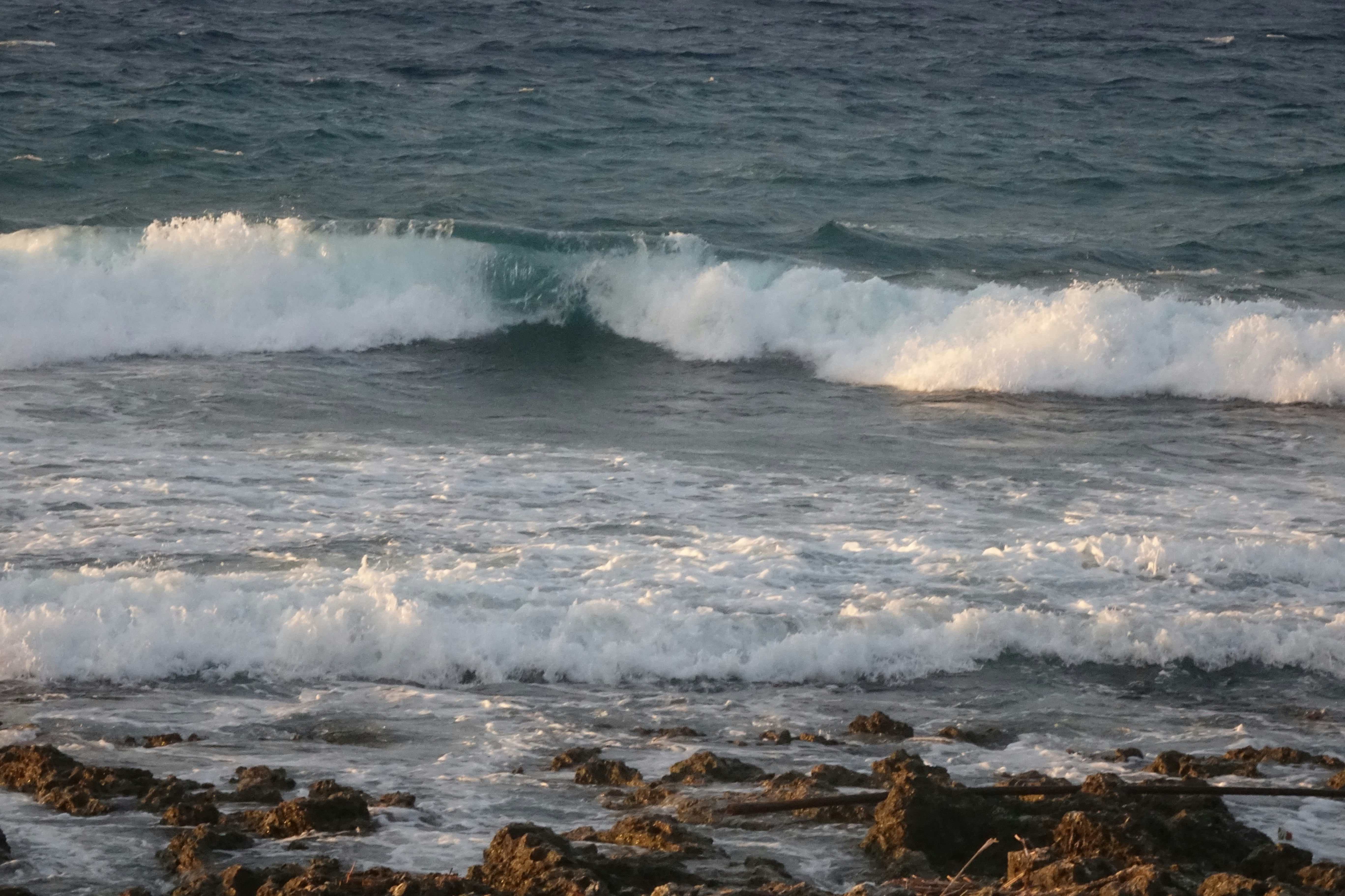 A person riding a surfboard on a wave in the ocean