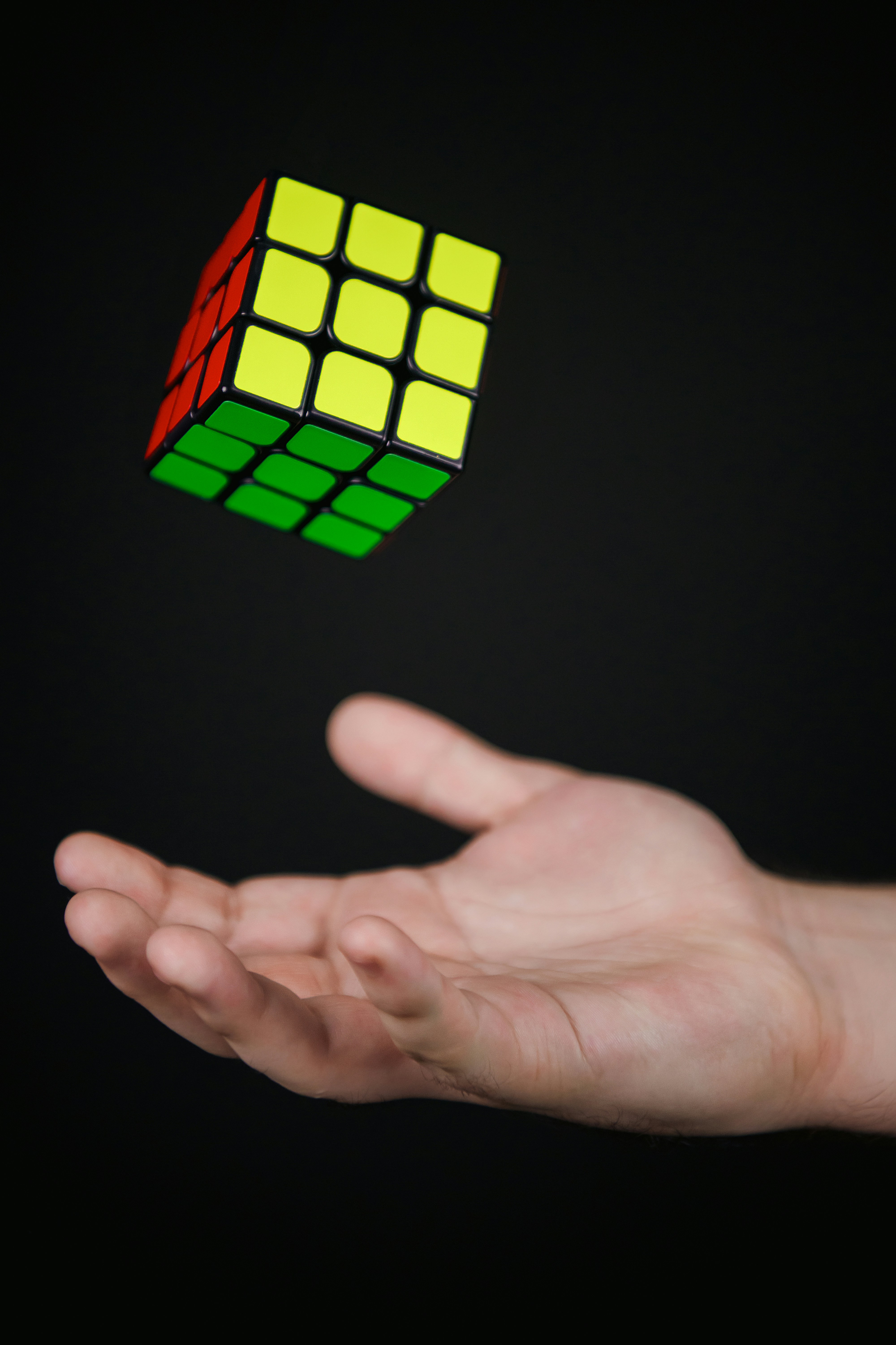 A hand holding a rubik cube in the air
