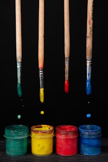 A group of paint brushes hanging from the ceiling