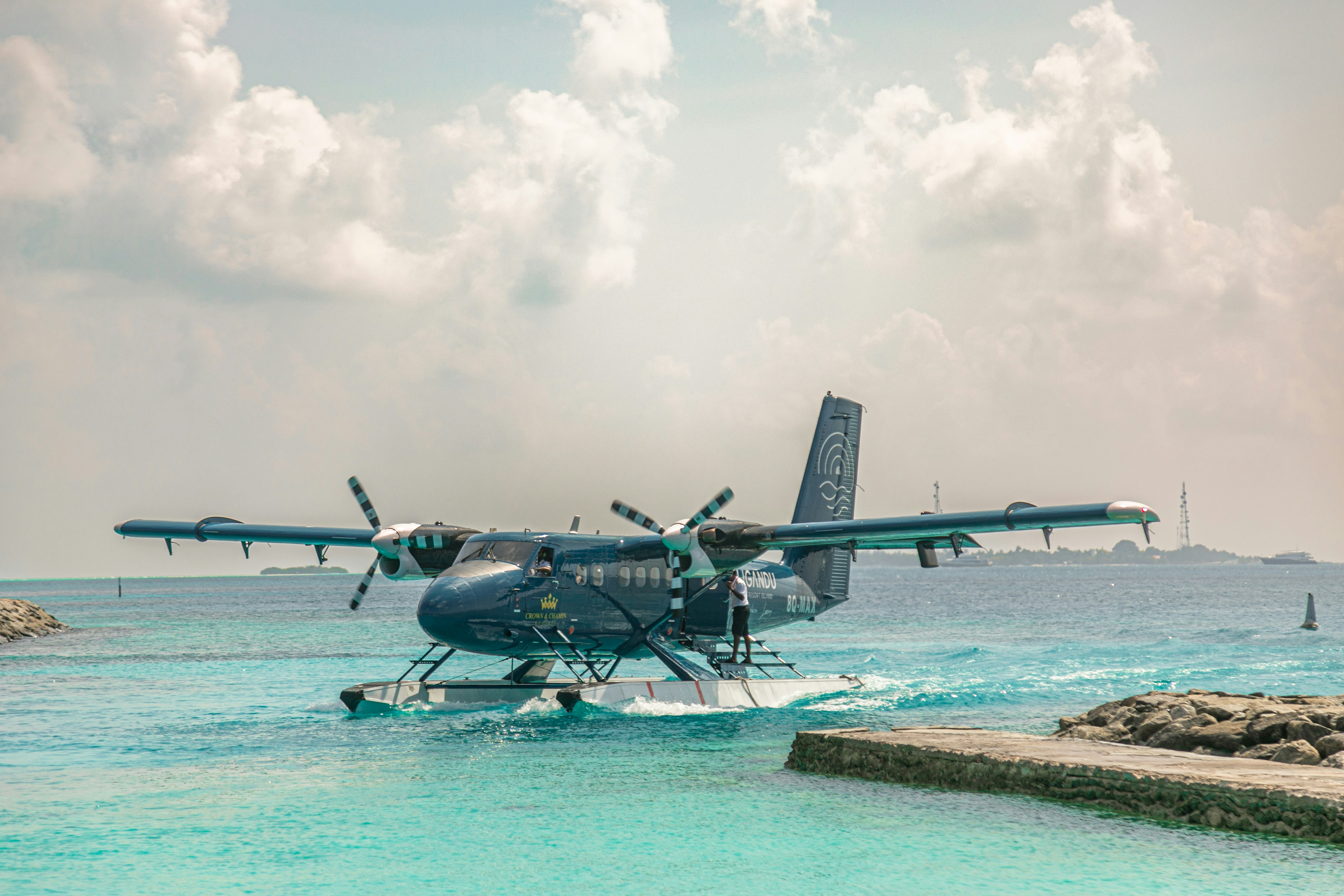 A seaplane is sitting on the water near the shore, 