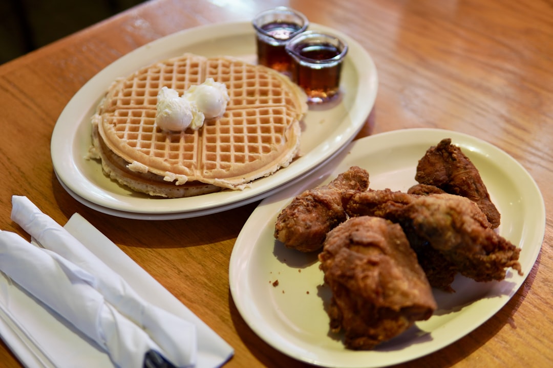 Two plates of chicken and waffles on a table