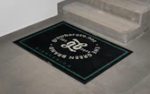 A black door mat with a snake on it