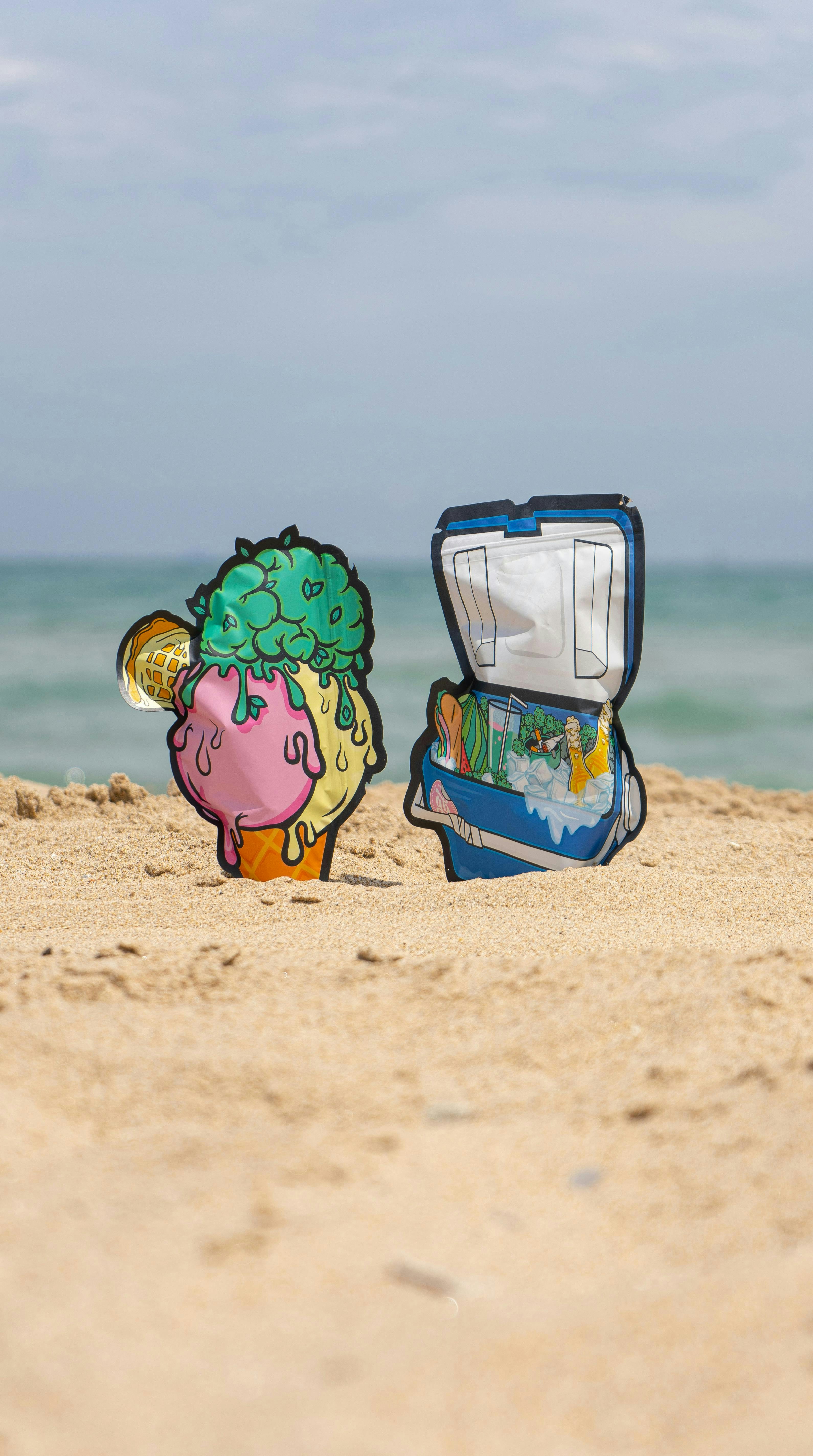 A beach scene with an open suitcase and an ice cream cone