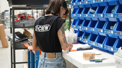A woman standing in front of a shelf of blue bins