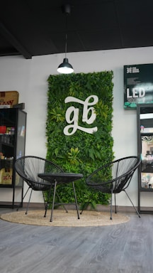 A green wall in a store with two chairs and a table
