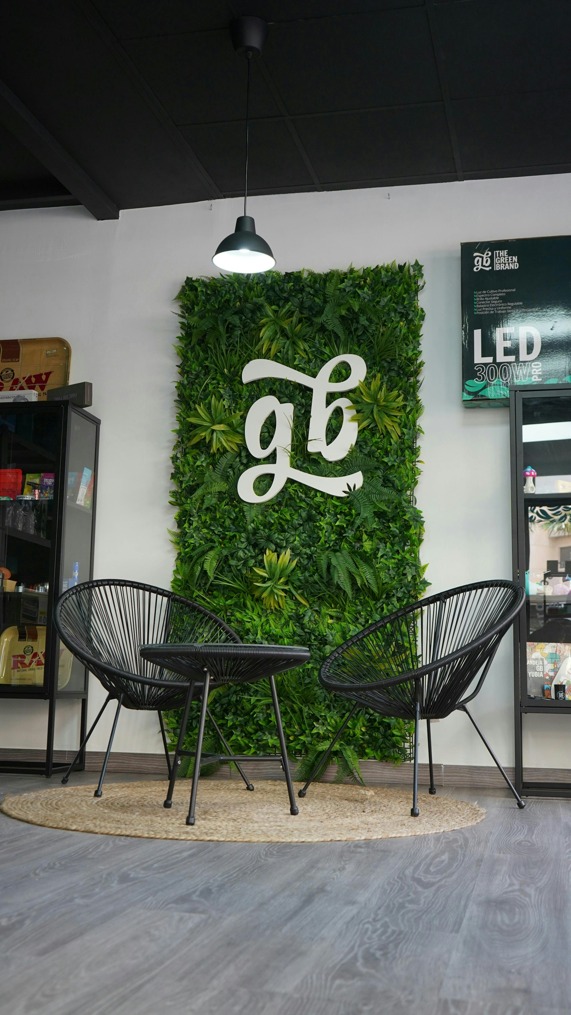 A green wall in a store with two chairs and a table