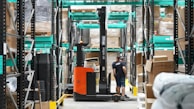 A man standing in a warehouse with a fork lift