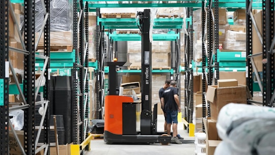 A man standing in a warehouse with a fork lift