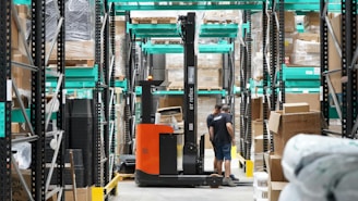 A man standing in a warehouse with a fork lift