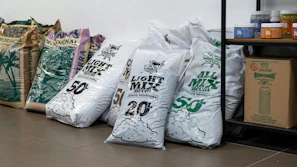 Bags of food are lined up against a wall