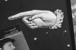 A black and white photo of a person pointing at something