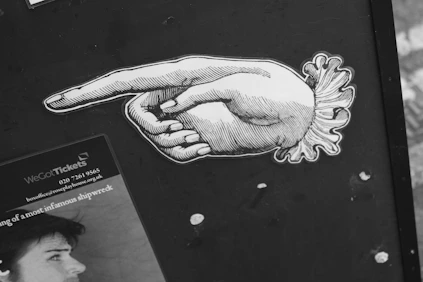 A black and white photo of a person pointing at something